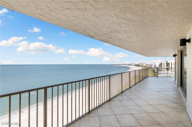 balcony with a water view and a beach view