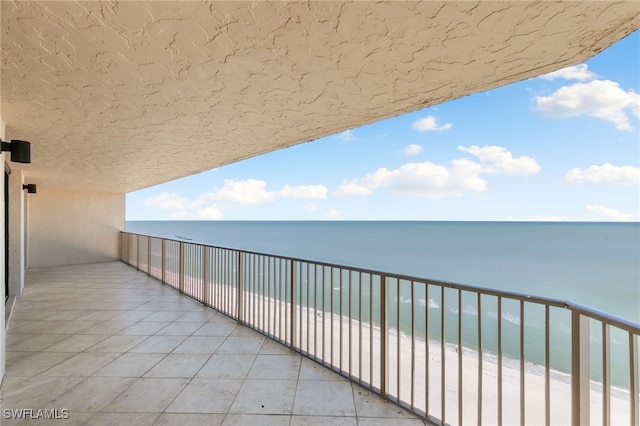 balcony with a water view and a beach view