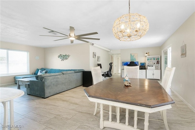 dining area featuring ceiling fan with notable chandelier