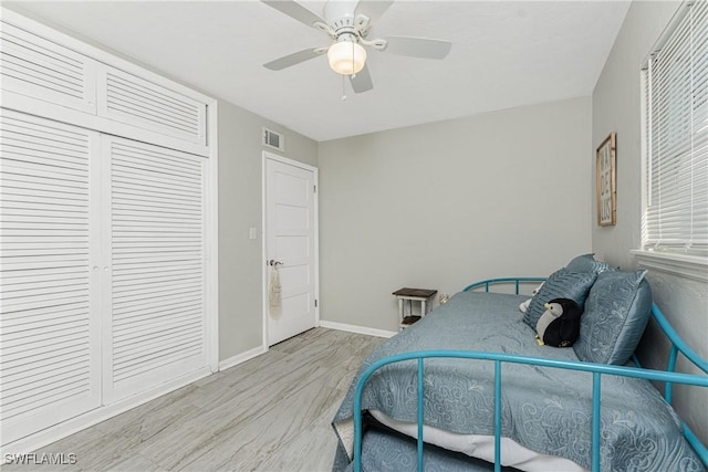 bedroom with ceiling fan, light hardwood / wood-style floors, and a closet