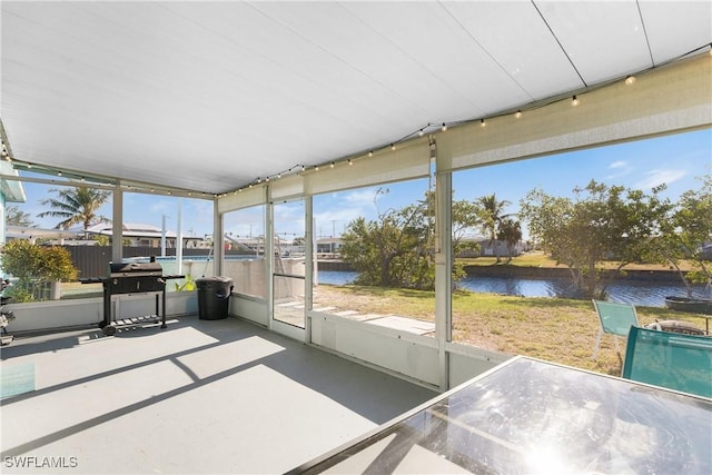 unfurnished sunroom featuring a water view