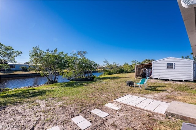 view of yard featuring a water view and a shed