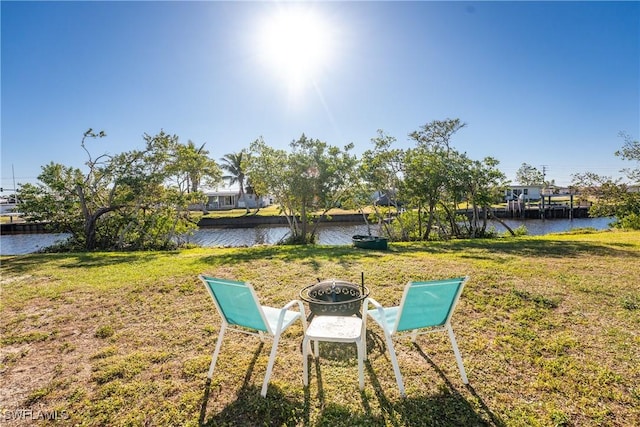 view of yard featuring a water view and a fire pit