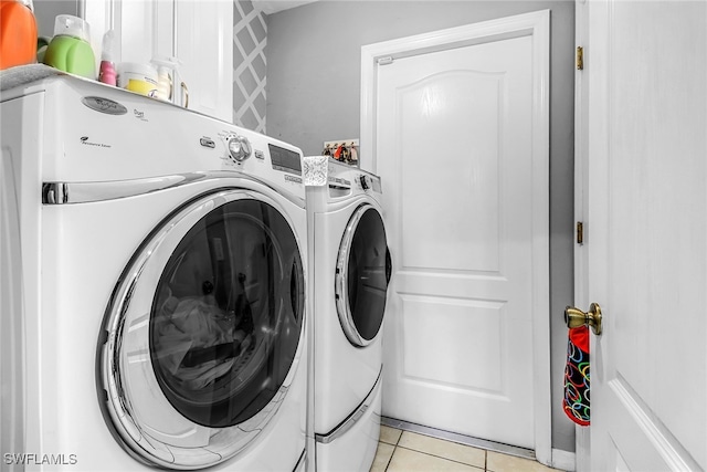 laundry area with light tile patterned floors and washing machine and clothes dryer