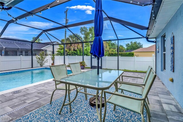 709 SW 9th Ct, Cape Coral, FL 33991 - view of swimming pool featuring a fenced backyard, a patio, glass enclosure, and outdoor dining space