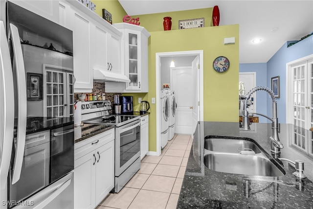 kitchen with appliances with stainless steel finishes, sink, separate washer and dryer, white cabinetry, and lofted ceiling