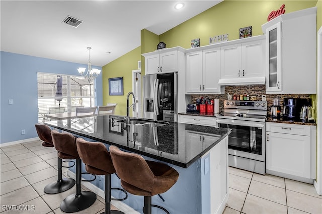 kitchen featuring a kitchen island with sink, sink, vaulted ceiling, stainless steel appliances, and a chandelier