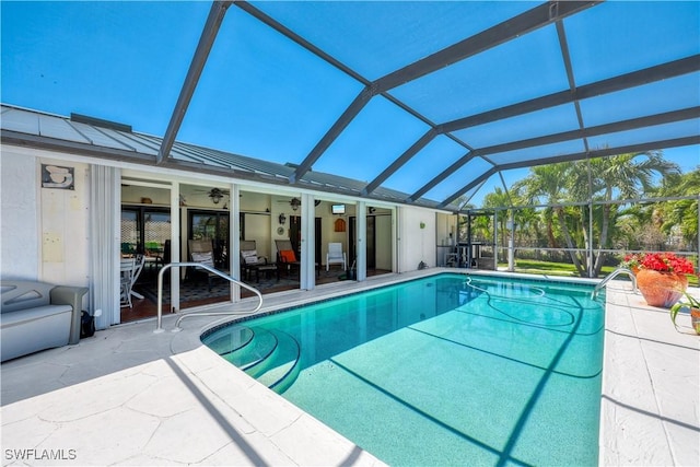 view of swimming pool with a lanai, ceiling fan, and a patio area