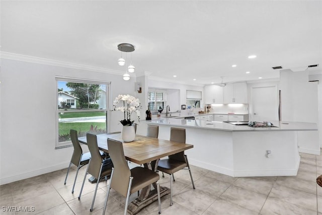 tiled dining area with crown molding and sink