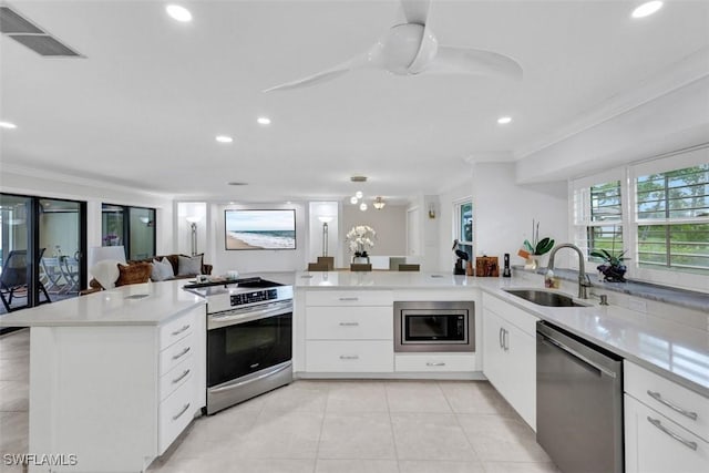 kitchen featuring kitchen peninsula, appliances with stainless steel finishes, crown molding, sink, and white cabinetry