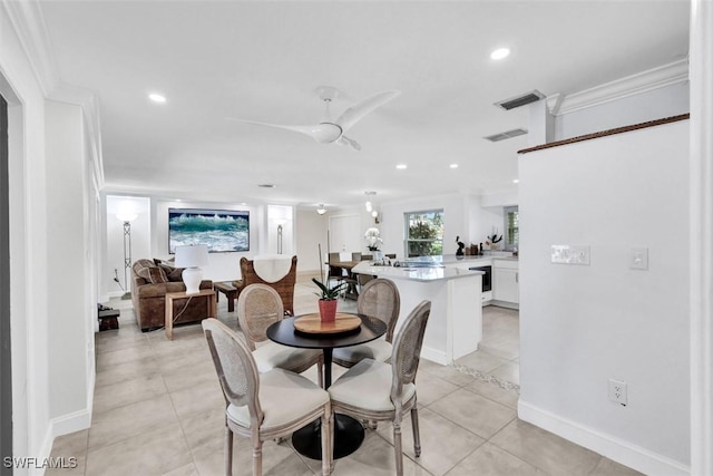 tiled dining area featuring ceiling fan and crown molding