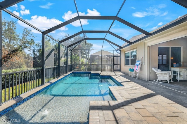 view of swimming pool with a patio, a fenced in pool, and a lanai