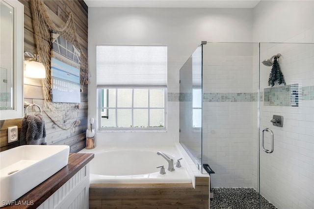 bathroom featuring a bath, a shower stall, and vanity