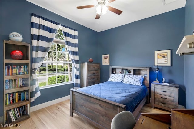 bedroom with a ceiling fan, wood finished floors, and baseboards