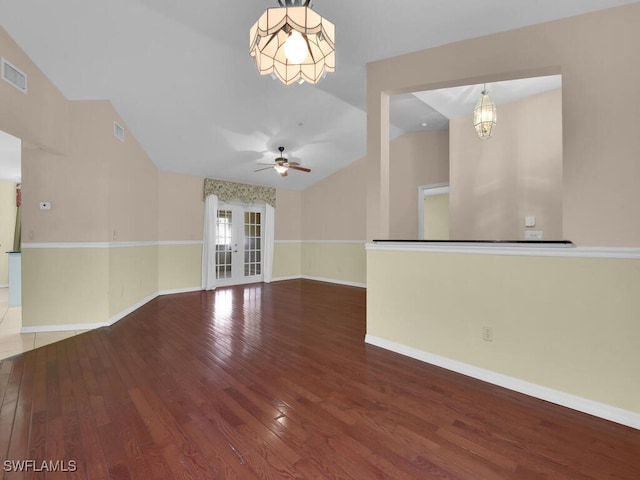 unfurnished room featuring hardwood / wood-style flooring, ceiling fan with notable chandelier, and vaulted ceiling