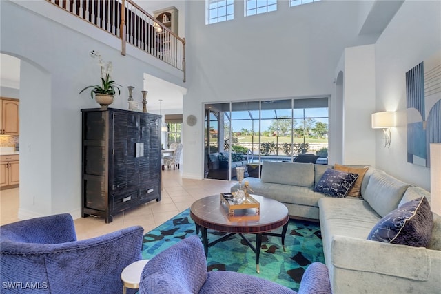 living room featuring a towering ceiling and light tile patterned floors