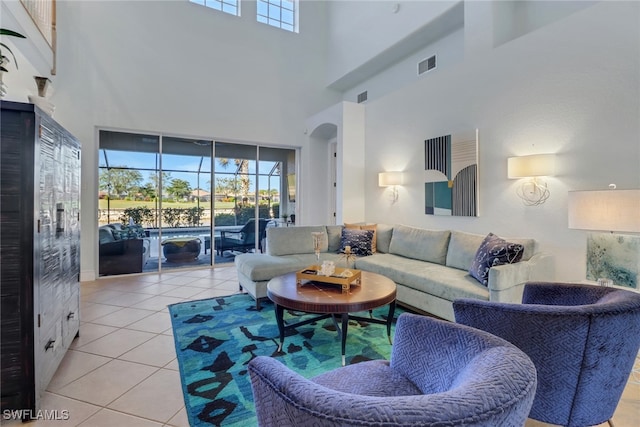 living room with light tile patterned flooring and a towering ceiling