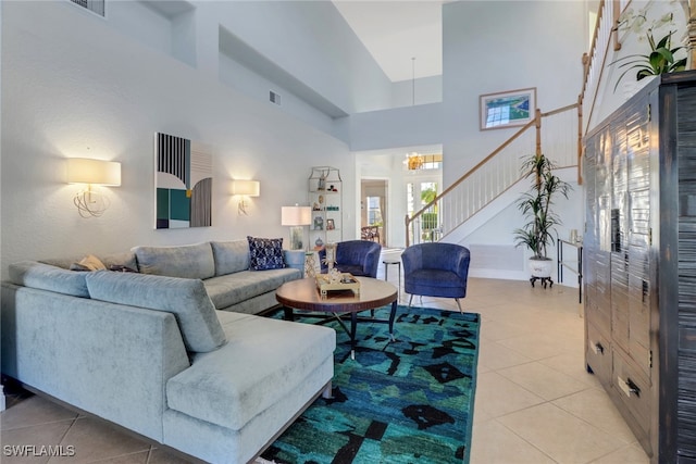 living room with a chandelier, light tile patterned floors, and a high ceiling