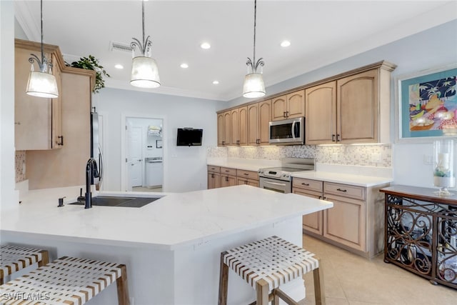 kitchen with pendant lighting, a kitchen breakfast bar, sink, kitchen peninsula, and stainless steel appliances