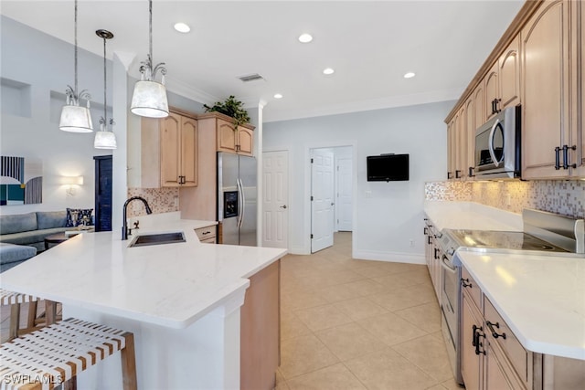 kitchen featuring light brown cabinets, sink, stainless steel appliances, kitchen peninsula, and decorative light fixtures