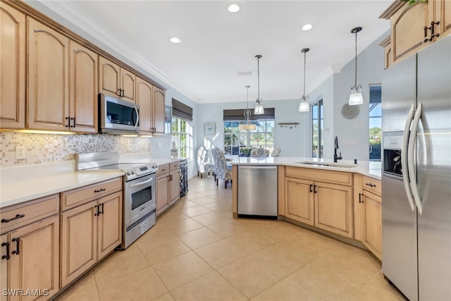 kitchen featuring sink, stainless steel appliances, decorative light fixtures, and light brown cabinets