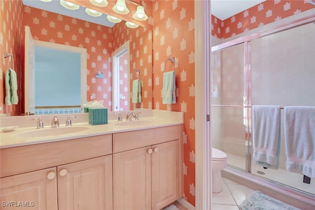 bathroom featuring toilet, vanity, tile patterned floors, and an enclosed shower