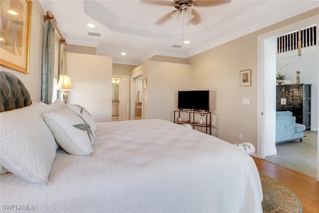 bedroom with light hardwood / wood-style flooring, ceiling fan, and ornamental molding