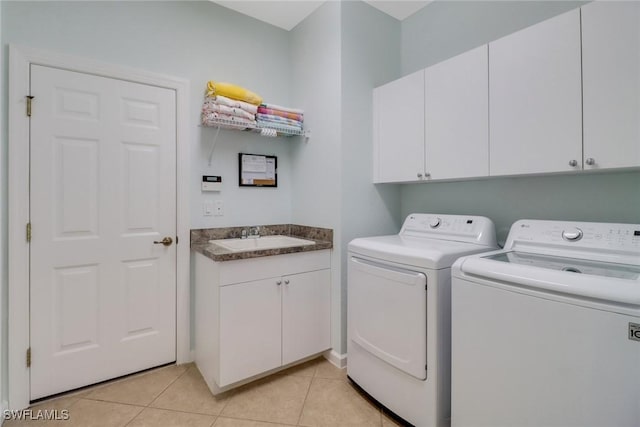 laundry area with cabinets, sink, light tile patterned floors, and washer and dryer