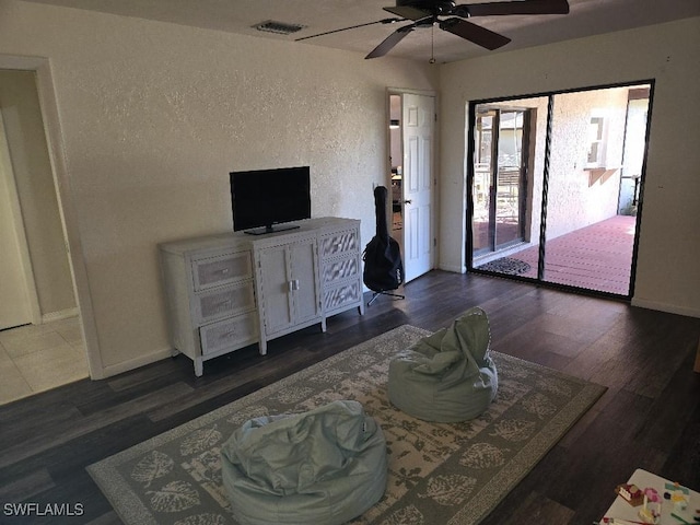 living room with ceiling fan and dark hardwood / wood-style flooring