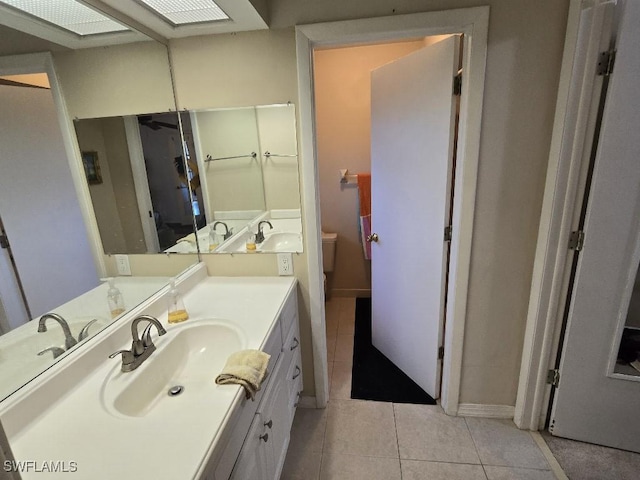 bathroom featuring tile patterned flooring, vanity, and toilet