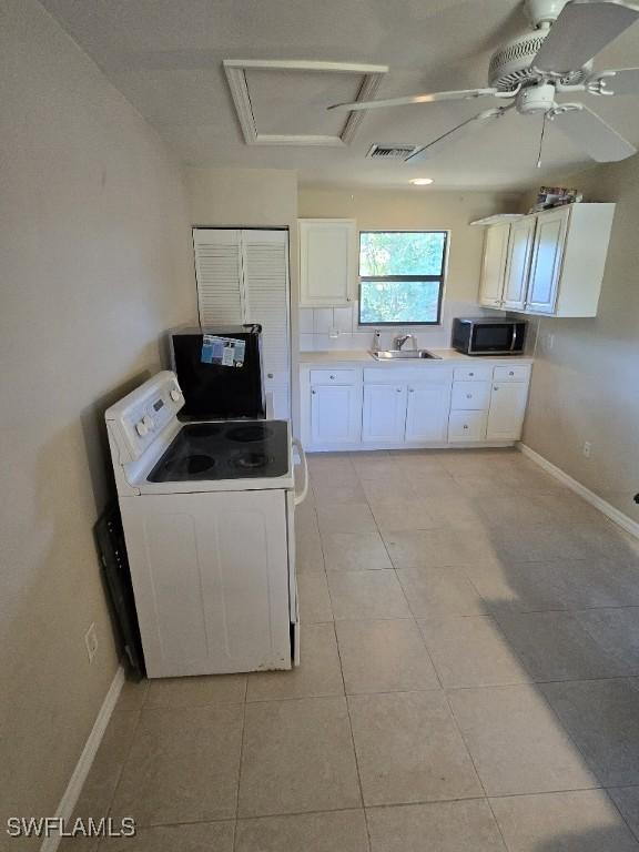 kitchen with ceiling fan, sink, white electric stove, white cabinetry, and light tile patterned flooring