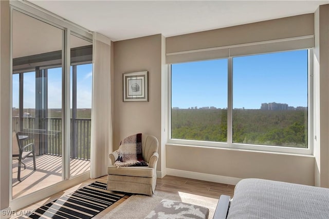 bedroom with access to exterior and light wood-type flooring