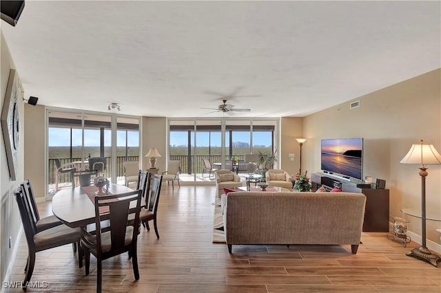 living room featuring floor to ceiling windows, wood-type flooring, and ceiling fan