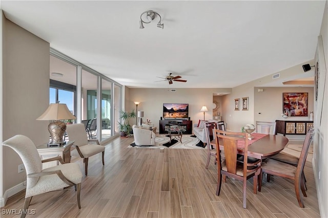 dining area with light wood-type flooring and ceiling fan