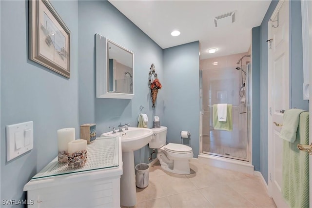 bathroom with tile patterned flooring, a shower with shower door, and toilet