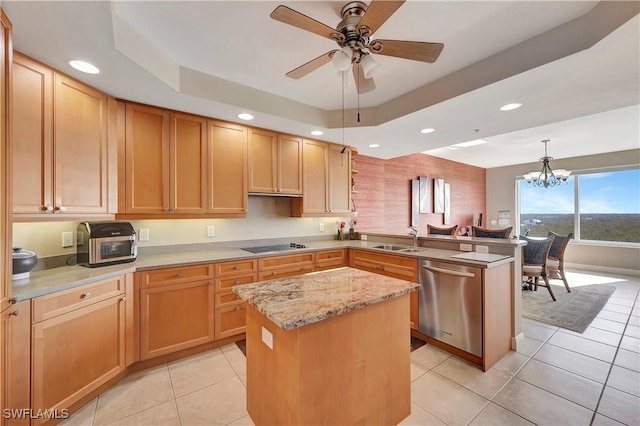 kitchen featuring stainless steel dishwasher, decorative light fixtures, a kitchen island, and a tray ceiling