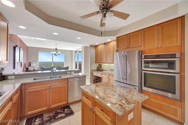 kitchen featuring stainless steel appliances, sink, light tile patterned floors, a kitchen island, and hanging light fixtures