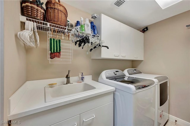 laundry room with cabinets, washer and clothes dryer, and sink