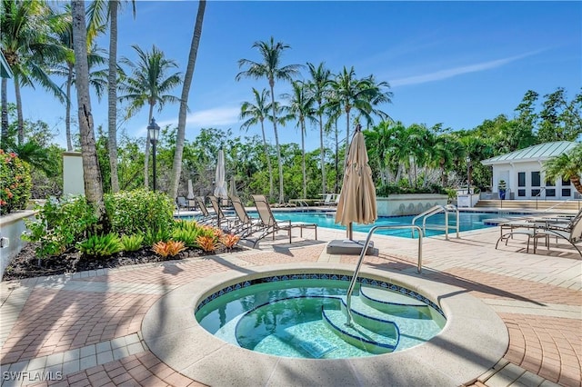 view of pool with a patio area and a hot tub