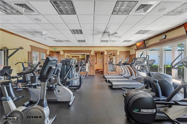 exercise room featuring a paneled ceiling, ceiling fan, crown molding, and a wealth of natural light