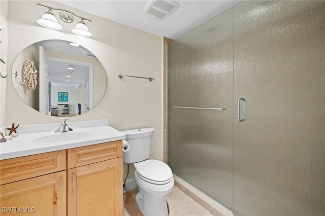 bathroom featuring tile patterned floors, vanity, a shower with shower door, and toilet