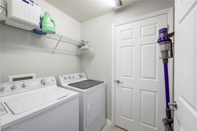 laundry room featuring washer and clothes dryer and a textured ceiling