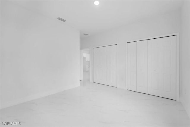 unfurnished bedroom with multiple closets