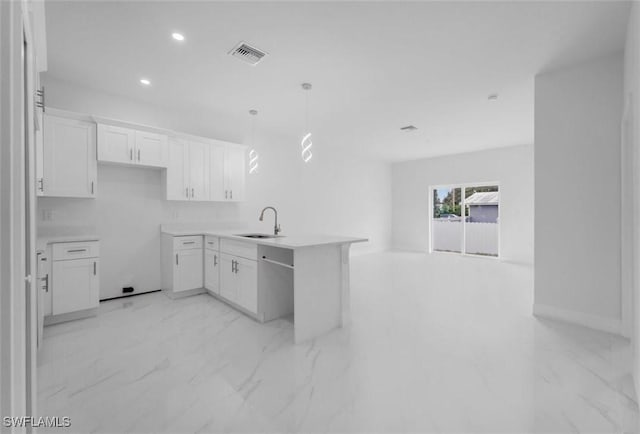 kitchen with white cabinets, decorative light fixtures, and sink