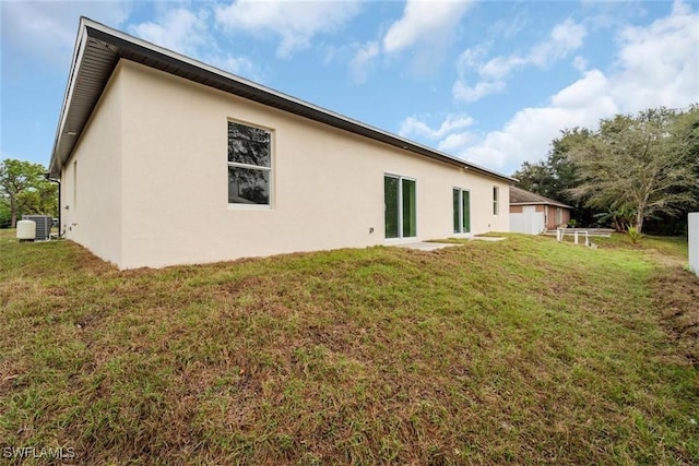 back of property featuring a yard and central air condition unit