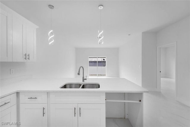 kitchen with white cabinets, decorative light fixtures, and sink