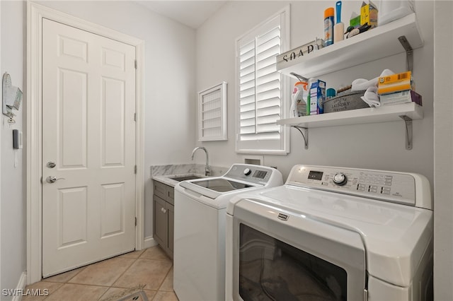 laundry area featuring washer and clothes dryer, cabinets, light tile patterned floors, and sink