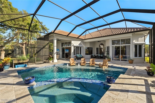 view of pool with glass enclosure, ceiling fan, a patio, and an in ground hot tub