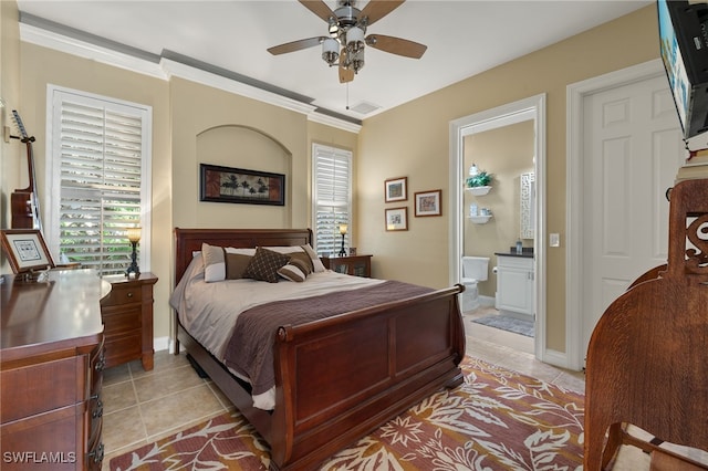 bedroom featuring ceiling fan, light tile patterned floors, ornamental molding, and connected bathroom