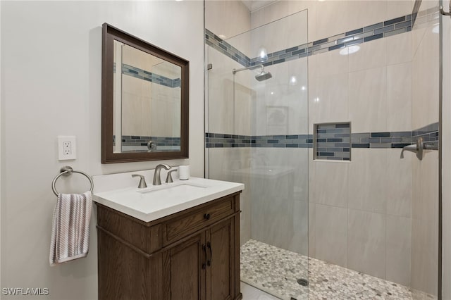 bathroom featuring tiled shower and vanity